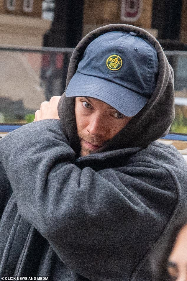 La productora de As It Was intentó mantener un perfil bajo mientras se envolvía en una sudadera con capucha gris y una gorra de béisbol azul para el viaje.