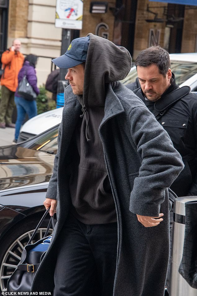 La estrella completó el look con un abrigo de invierno gris oscuro mientras llevaba sus accesorios en un bolso de viaje de cuero negro.