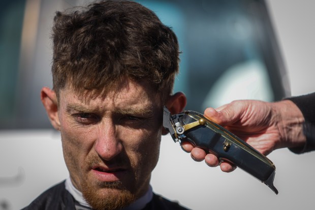 Scott Llewellyn, que vive en un campamento en Redwood City, es cortado por Joseph Kautz en el campamento en Redwood City, California, el sábado 10 de febrero de 2024. (Shae Hammond/Bay Area Newsgroup)