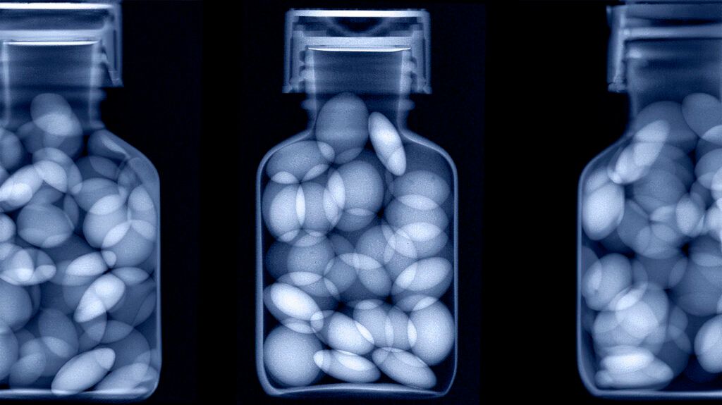 Una radiografía azul de las pastillas en el frasco.