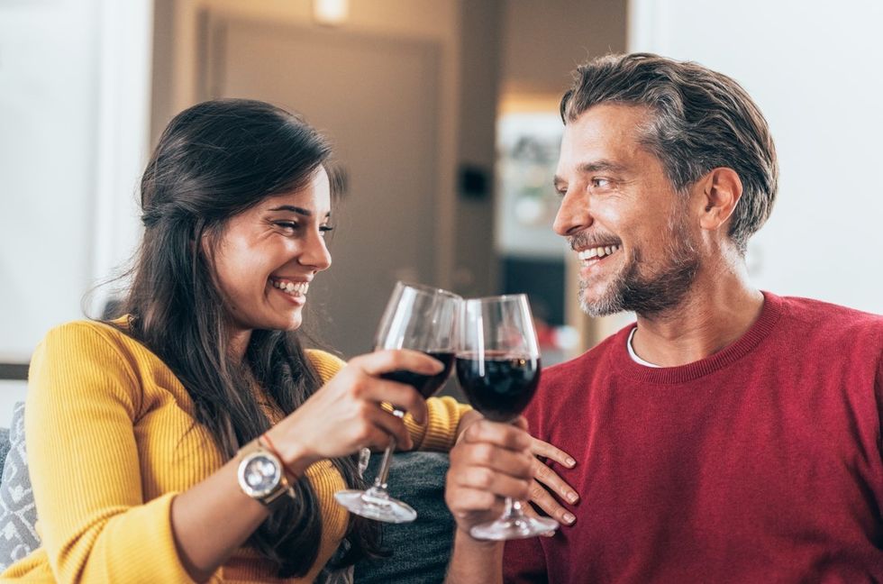 La pareja bebe vino tinto.