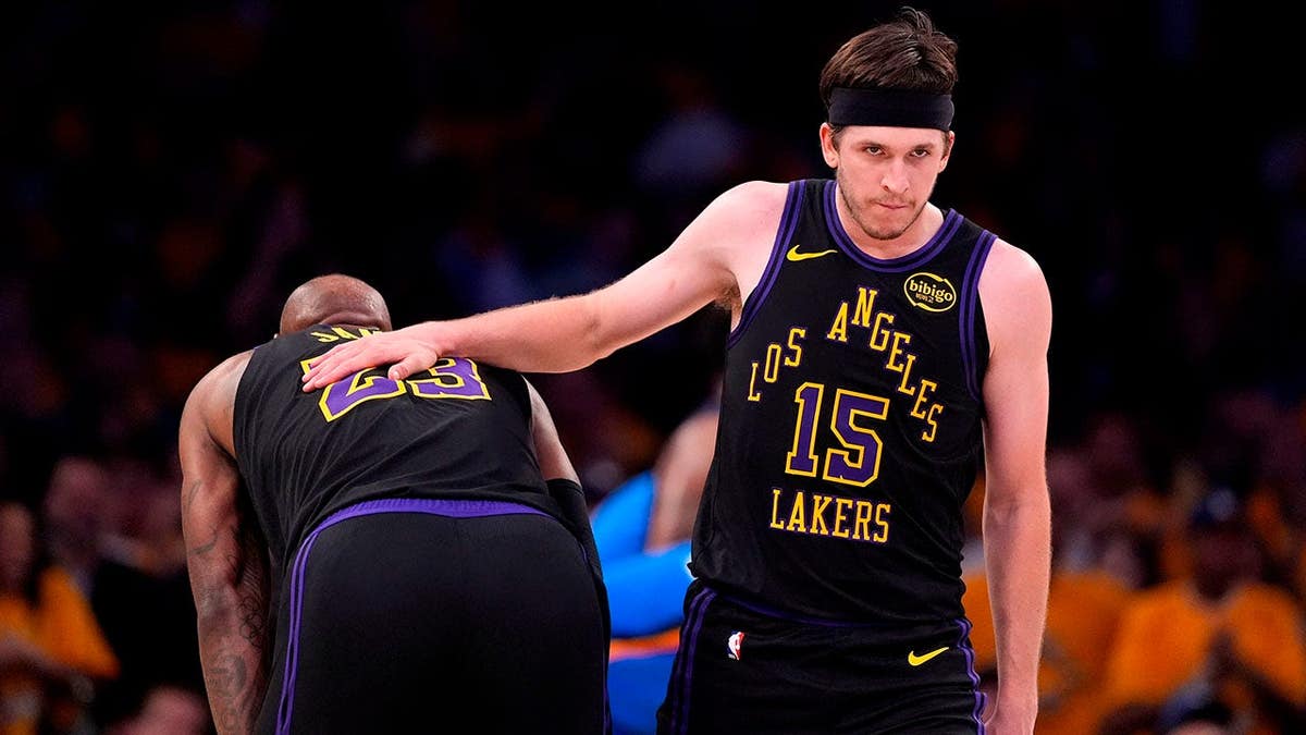 El base de Los Angeles Lakers, Austin Reaves, le da una palmada en la espalda a LeBron James durante el juego.